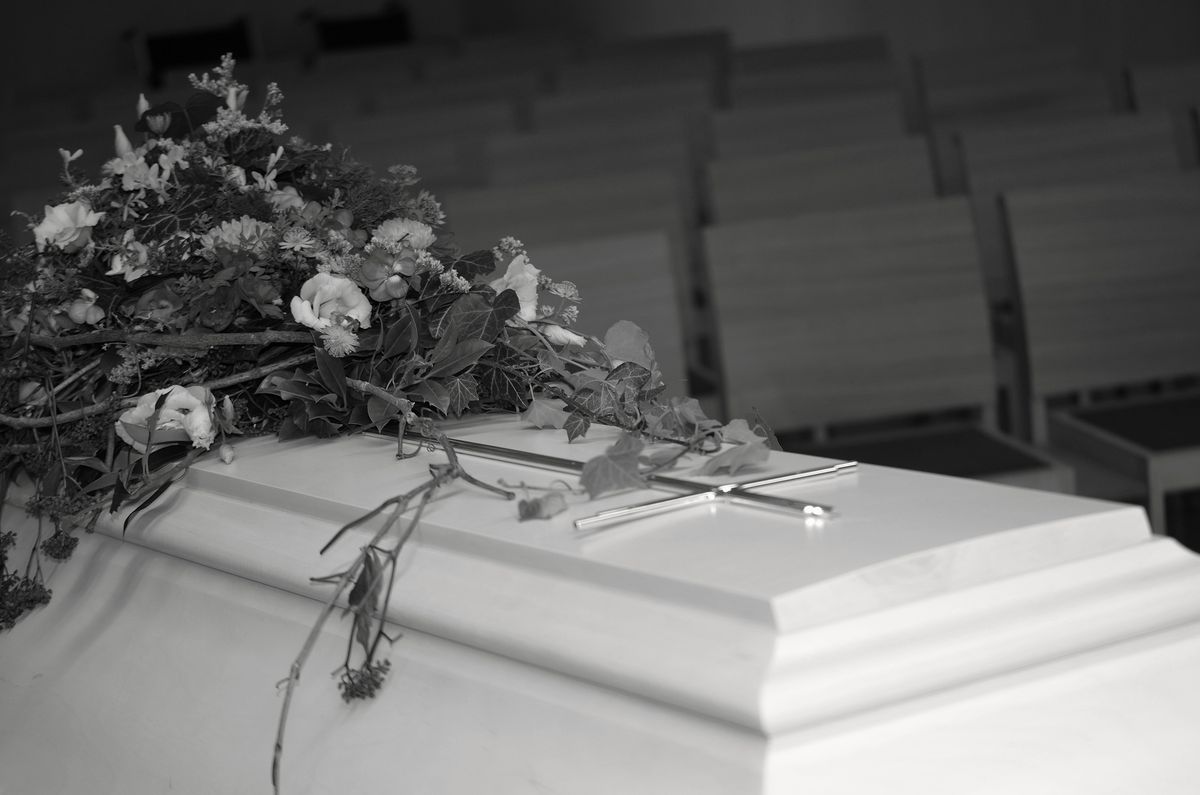 Hvid kiste med blomster i et kapel